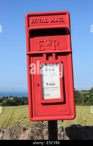 Newly painted wonky red Royal Mail postbox leaning sideways against blue sky. UK, Stock Photo