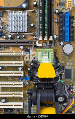 Robotic arm installing a computer chip on a motherboard. Stock Photo