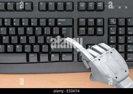 Robot hand typing on a computer keyboard. Stock Photo
