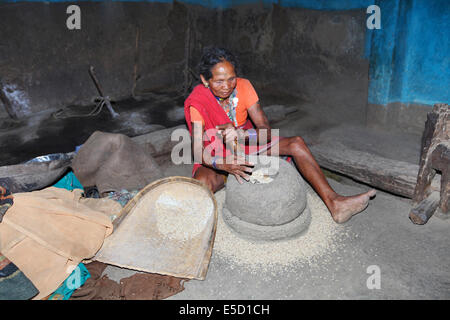 Tribal women grinding rice, Baiga tribe. Karangra Village, Chattisgadh, India Stock Photo