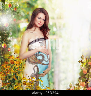 Maternity. Pregnant Smiling Woman in Nature Expecting Baby Stock Photo