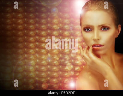 Fantasy. Beautiful Woman over Sparkling Gold Background Stock Photo