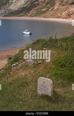 Coast Path stone sign waymarker at Worbarrow Bay with views of the bay, Isle of Purbeck, Dorset UK In July Stock Photo