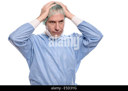Depressed surgeon in theater garb or scrubs holding his hands to his head with a grim expression isolated on white Stock Photo