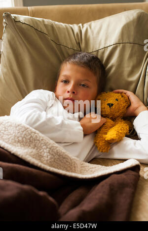 child feeling sick in bed Stock Photo