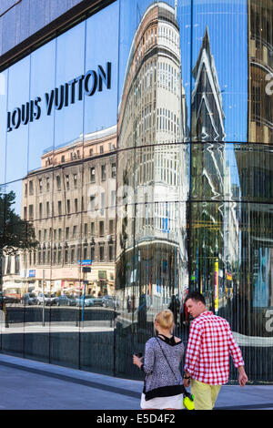 Architectural reflections and people walking past the Louis Vuitton shop at the Vitkac Department Store in Bracka street, Warsaw Stock Photo