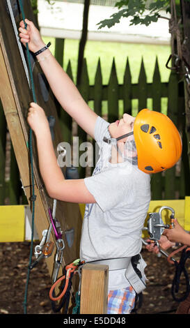 Young boy engaged in climbing on the tree. Stock Photo