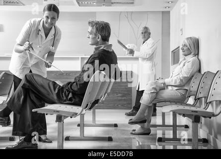 Doctors and patients in hospital waiting room. Stock Photo