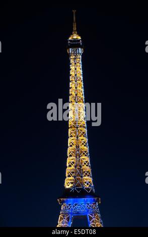 Eiffel Tower by night lit up with blue and yellow lights Stock Photo