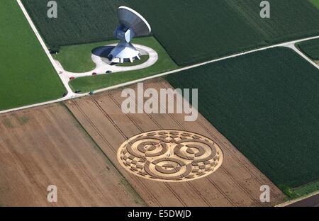 Raisting, Germany. 28th July, 2014. Visitors walks thorugh a crop circle in a wheat field next to an antenna of the earth station near Raisting, Germany, 28 July 2014. A balloonist had discovered the crop circle about a week ago. Photo: Karl-Josef Hildenbrand/dpa/Alamy Live News Stock Photo