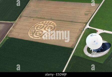 Raisting, Germany. 28th July, 2014. Visitors walk thorugh a crop circle in a wheat field next to an antenna of the earth station near Raisting, Germany, 28 July 2014. A balloonist had discovered the crop circle about a week ago. Photo: Karl-Josef Hildenbrand/dpa/Alamy Live News Stock Photo