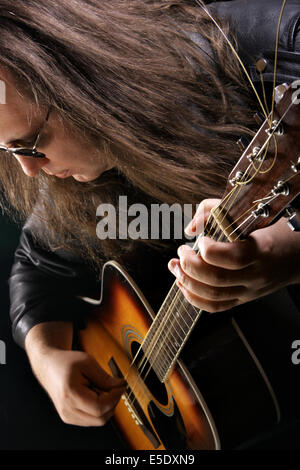 Man playing acoustic guitar at rock concert Stock Photo