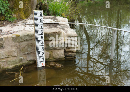 Lake overflow conduit with water level depth gauge Stock Photo