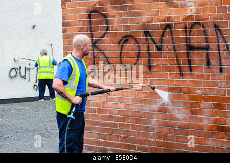 Belfast, Northern Ireland. 29th July, 2014. A council worker removes graffiti saying 'Romanians Out' spraypainted  on a wall in Belfast. Credit:  Stephen Barnes/Alamy Live News Stock Photo