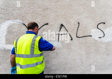 Belfast, Northern Ireland. 29th July, 2014. A council worker removes graffiti saying 'Locals Only' spraypainted  on a wall in Belfast. Credit:  Stephen Barnes/Alamy Live News Stock Photo