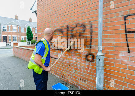 Belfast, Northern Ireland. 29th July, 2014. A council worker removes graffiti saying 'C18' [Combat 18] spraypainted  on a wall in Belfast. Credit:  Stephen Barnes/Alamy Live News Stock Photo