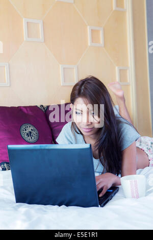 young Asian woman using laptop computer working from home sitting on ...