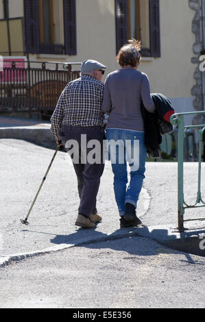 An old man helped by a younger woman to walk and cross the street. It is an intergenerational illustration. Stock Photo