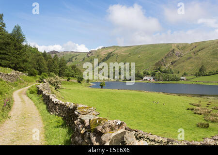 Track and drystone walls at Watendlath Tarn, Borrowdale, Lake District, UK, in summer with blue sky and white clouds Stock Photo