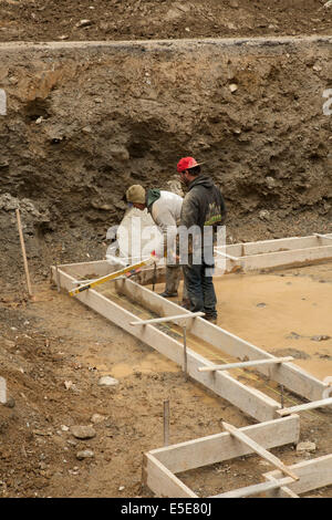 Workers check level as they frame the foundation of a residential building in the Berkshires of Massachusetts. Stock Photo