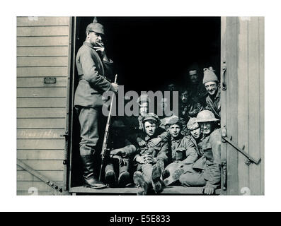 World War One captured British soldiers in railway carriage being guarded by WW1 German soldier wearing typical spiked helmet Stock Photo