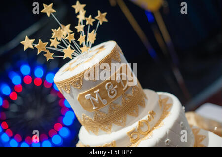 Top tier of a celebration golden wedding cake with letters M & D for mum and dad and a burst of sugar stars on top of the icing Stock Photo