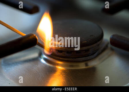 match lit the gas burner in the kitchen Stock Photo