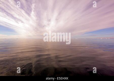 Sun rays through clouds above the ocean, Greenland Stock Photo