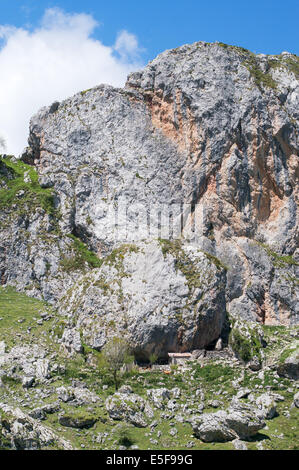 A remote building sheltering under an overhanging rocky outcrop near lake Ercina , Picos de Europa National Park Asturias, Spain Stock Photo