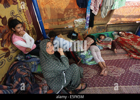Gaza City, Gaza Strip, Palestinian Territory. 30th July, 2014. Palestinians sit at a UN school at the Jabalia refugee camp in the northern Gaza Strip after the area was hit by Israeli shelling on July 30, 2014. Israeli bombardments early on July 30 killed ''dozens'' of Palestinians in Gaza, including at least 16 at a UN school, medics said, on day 23 of the Israel-Hamas conflict Credit:  Ashraf Amra/APA Images/ZUMA Wire/Alamy Live News Stock Photo