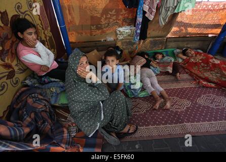 Gaza City, Gaza Strip, Palestinian Territory. 30th July, 2014. Palestinians sit at a UN school at the Jabalia refugee camp in the northern Gaza Strip after the area was hit by Israeli shelling on July 30, 2014. Israeli bombardments early on July 30 killed ''dozens'' of Palestinians in Gaza, including at least 16 at a UN school, medics said, on day 23 of the Israel-Hamas conflict Credit:  Ashraf Amra/APA Images/ZUMA Wire/Alamy Live News Stock Photo