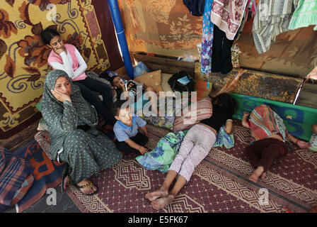 Gaza City, Gaza Strip, Palestinian Territory. 30th July, 2014. Palestinians sit at a UN school at the Jabalia refugee camp in the northern Gaza Strip after the area was hit by Israeli shelling on July 30, 2014. Israeli bombardments early on July 30 killed ''dozens'' of Palestinians in Gaza, including at least 16 at a UN school, medics said, on day 23 of the Israel-Hamas conflict Credit:  Ashraf Amra/APA Images/ZUMA Wire/Alamy Live News Stock Photo