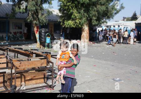 Gaza City, Gaza Strip, Palestinian Territory. 30th July, 2014. Palestinians sit at a UN school at the Jabalia refugee camp in the northern Gaza Strip after the area was hit by Israeli shelling on July 30, 2014. Israeli bombardments early on July 30 killed ''dozens'' of Palestinians in Gaza, including at least 16 at a UN school, medics said, on day 23 of the Israel-Hamas conflict Credit:  Ashraf Amra/APA Images/ZUMA Wire/Alamy Live News Stock Photo