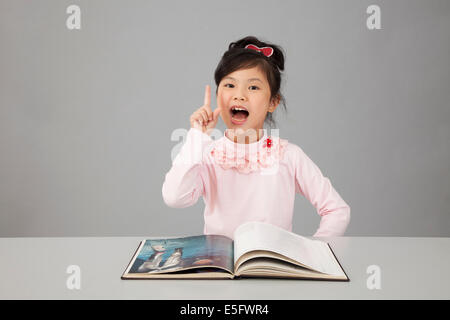 asian chinese kid happy reading encyclopedia Stock Photo