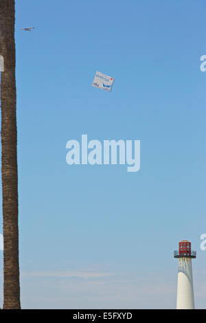 Banner Towing Aircraft Tows Aerial Advert Over Long Beach Waterfront On A Summer Weekend. Stock Photo