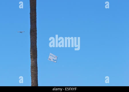 Banner Towing Aircraft Tows Aerial Advert Over Long Beach Waterfront On A Summer Weekend. Stock Photo