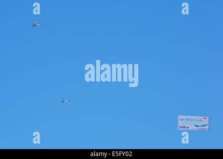 Banner Towing Aircraft Tows Aerial Advert Over Long Beach Waterfront On A Summer Weekend. Stock Photo