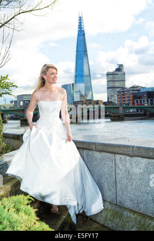 A bride standing on the north bank of the Thames in London with the Shard behind, London, England, UK Stock Photo