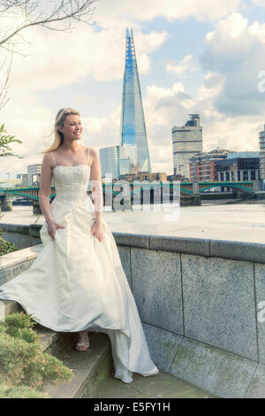 A bride standing on the north bank of the Thames in London with the Shard behind, London, England, UK Stock Photo