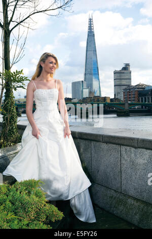 A bride standing on the north bank of the Thames in London with the Shard behind, London, England, UK Stock Photo
