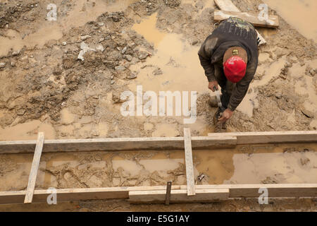 Worker hammers frame for the foundation of a residential building in the Berkshires of Massachusetts. Stock Photo