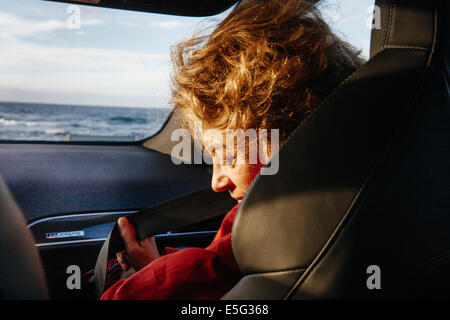 Woman fastening seat belt Stock Photo