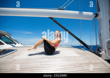 Woman stretching on boat Stock Photo