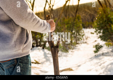 An senior aged retired man walking in the mountains for exercise with a walking stick Stock Photo