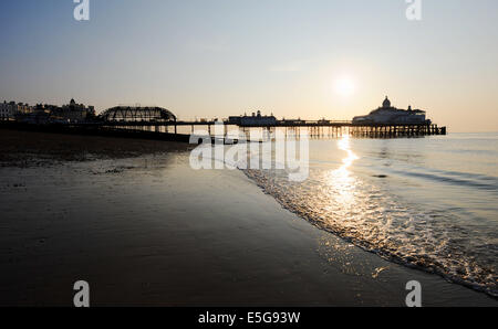 Eastbourne, Sussex, UK. 31st July, 2014.  The sun rises over the tangled wreck of Eastbourne Pier this morning the day after the front section was destroyed by fire Fire crews from all over Sussex battled to save the pier which caught alight yesterday afternoon and they are still damping it down this morning Stock Photo