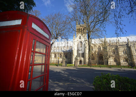 red telephone box by selby abbey at springtime founded in 1069 by benedict of Auxerre north yorkshire united kingdom Stock Photo