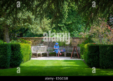 Woman reading book in Hidcote Garden near Chipping-Campden, the Cotswolds, Gloucestershire, England Stock Photo