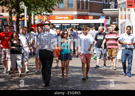 people walking through busy cornmarket on a hot sunny day in Belfast city centre Stock Photo