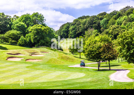 Bunkers, putting green and buggy on a typical golf course. Stock Photo