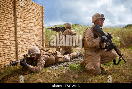 U.S. Marines assigned to India Company, 3rd Battalion, 3rd Marine Regiment, provide security outside of a compound wall during Stock Photo